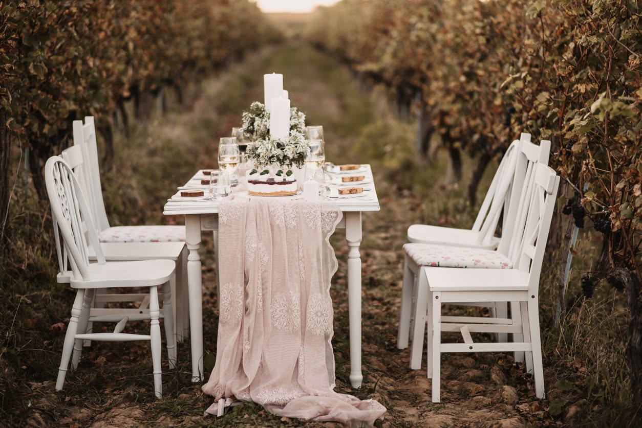 A small outdoor celebration table with flowers and white chairs