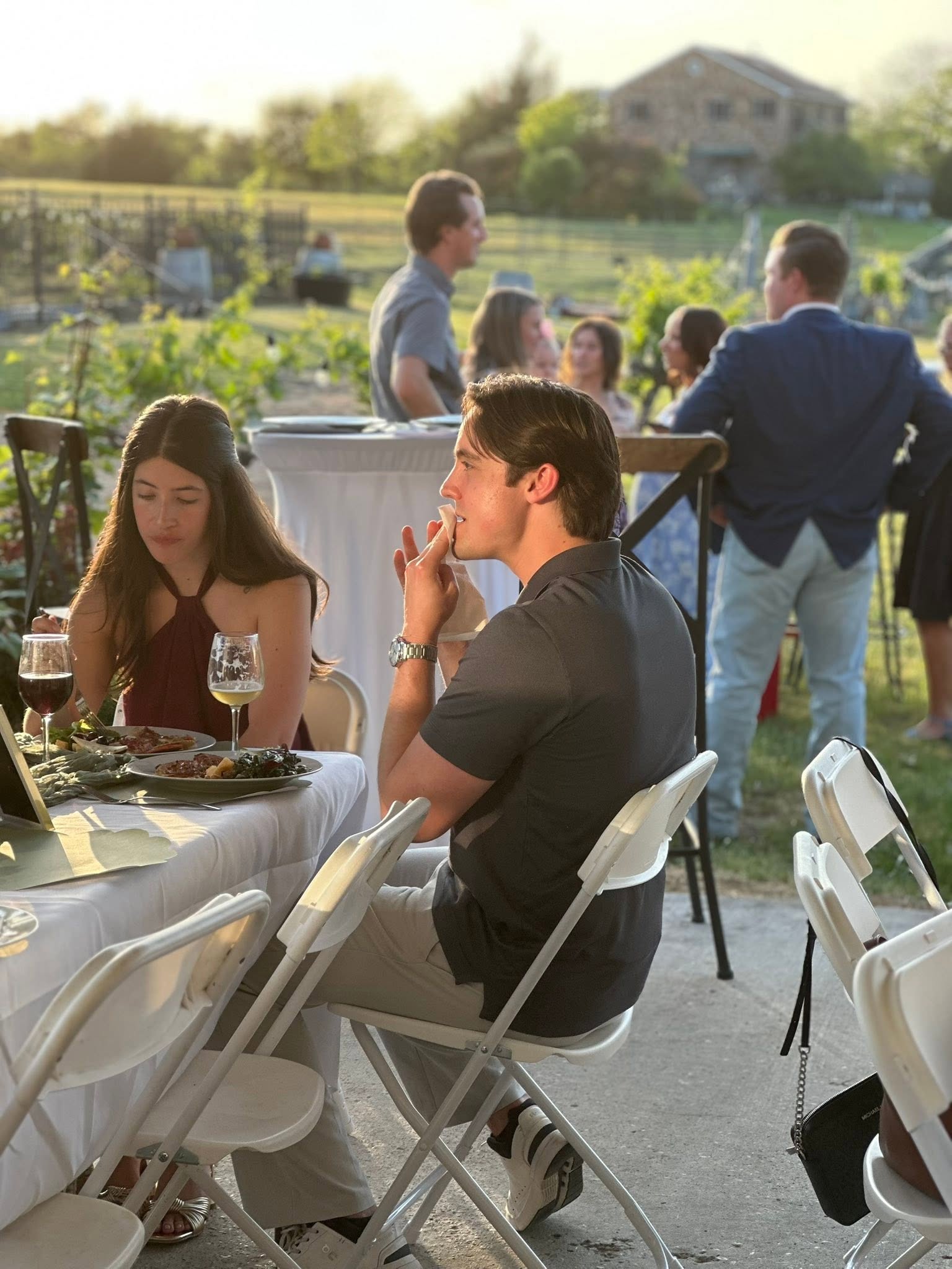 Guests gathered at outdoor tables beside the vines