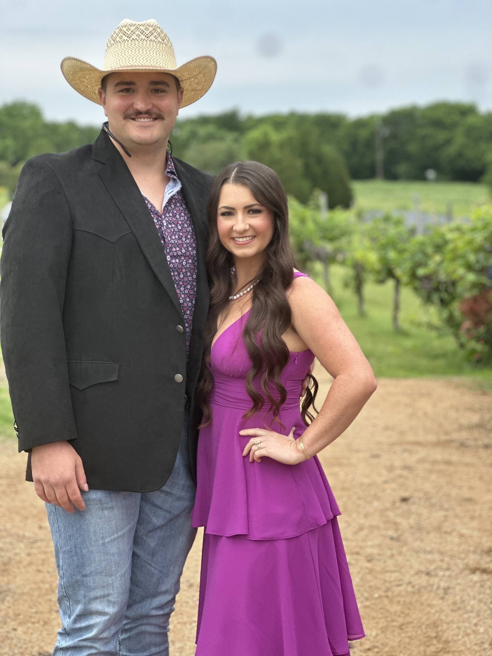Two guests posing beside the vineyard